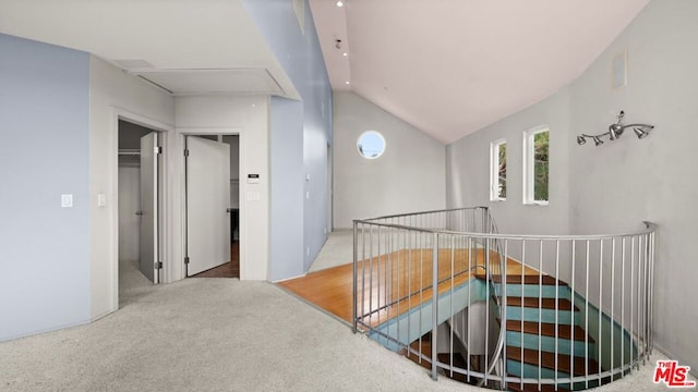 hall featuring lofted ceiling and light carpet