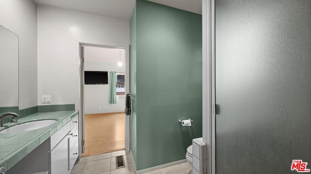 bathroom with toilet, tile patterned floors, and vanity