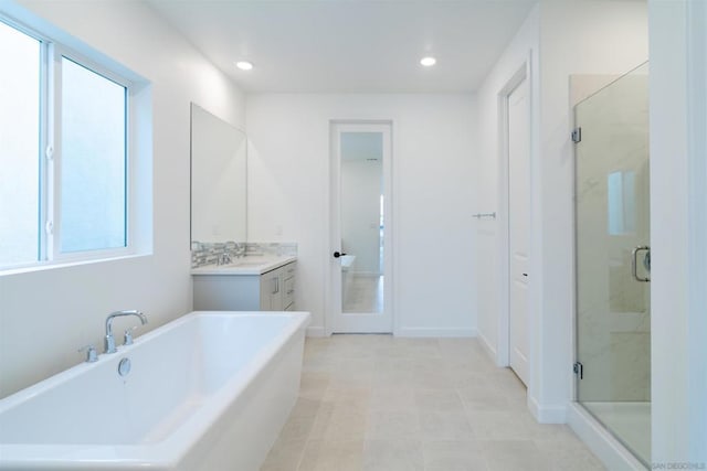 bathroom with vanity and shower with separate bathtub