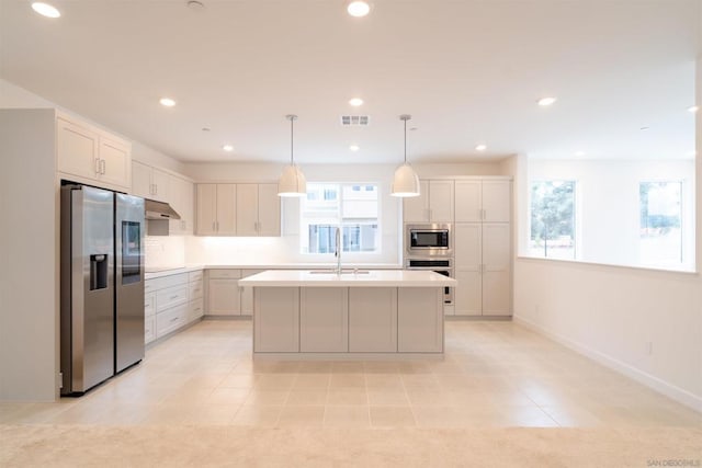 kitchen featuring pendant lighting, sink, appliances with stainless steel finishes, an island with sink, and light tile patterned floors