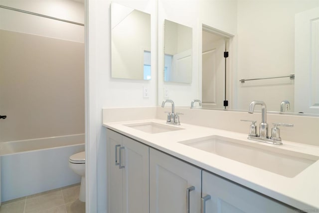 bathroom with toilet, vanity, and tile patterned floors