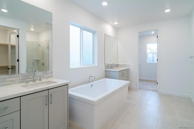 bathroom with vanity, a healthy amount of sunlight, independent shower and bath, and tasteful backsplash