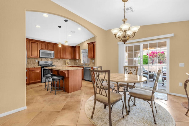 tiled dining room with lofted ceiling, a notable chandelier, and sink