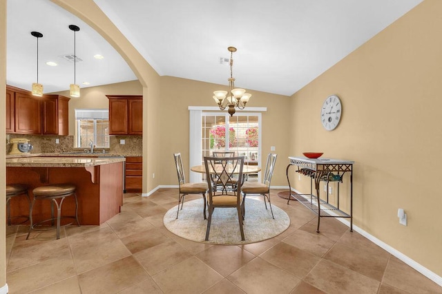 dining space featuring vaulted ceiling and a chandelier