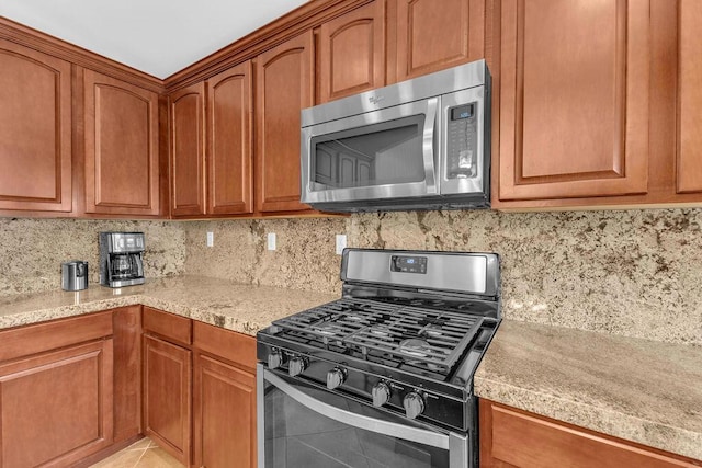 kitchen featuring decorative backsplash, light tile patterned floors, and stainless steel appliances