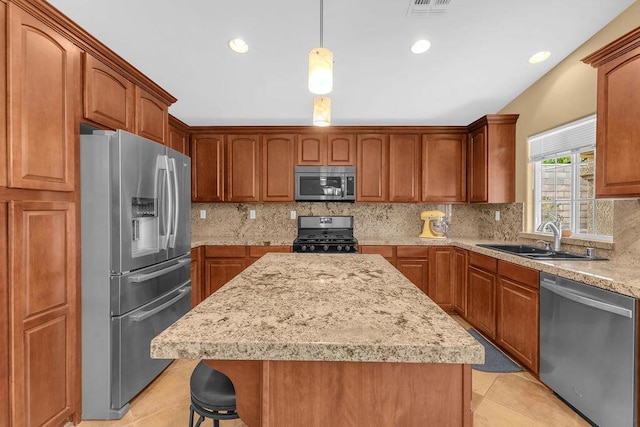 kitchen featuring appliances with stainless steel finishes, decorative backsplash, decorative light fixtures, and sink