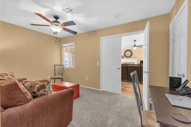 carpeted home office featuring ceiling fan