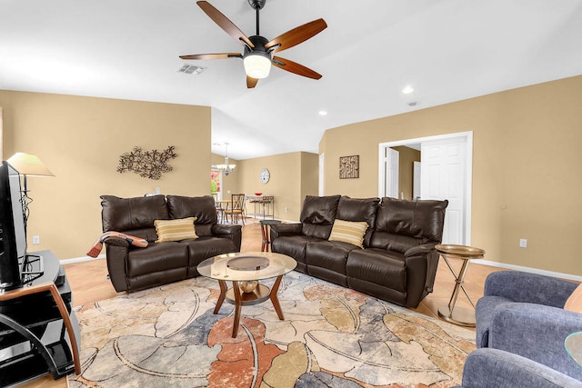 living room featuring lofted ceiling and ceiling fan with notable chandelier