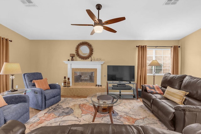 living room featuring a brick fireplace and ceiling fan