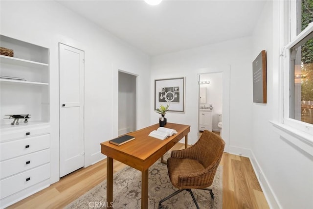 home office featuring a healthy amount of sunlight and light hardwood / wood-style flooring