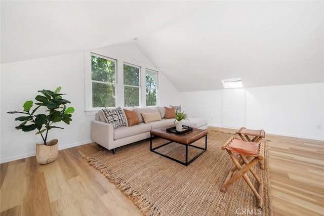 living room featuring light hardwood / wood-style floors and lofted ceiling with skylight