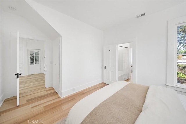 bedroom featuring ensuite bathroom and hardwood / wood-style floors