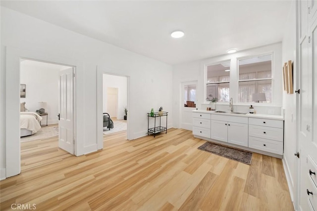 interior space featuring sink, white cabinetry, and light hardwood / wood-style flooring