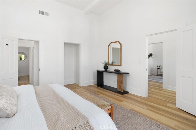 bedroom featuring hardwood / wood-style floors and a towering ceiling