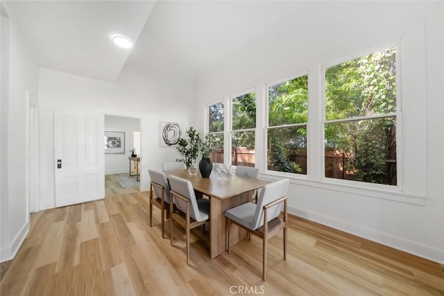 dining area with vaulted ceiling and light hardwood / wood-style flooring