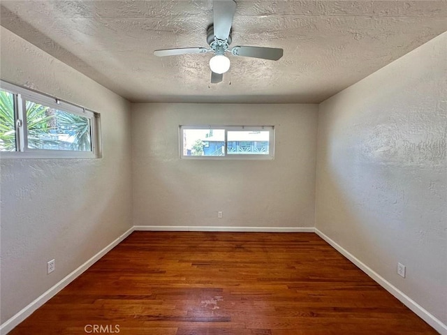 unfurnished room featuring a textured ceiling, ceiling fan, and dark hardwood / wood-style flooring