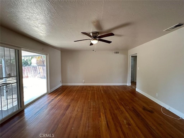 empty room with ceiling fan, dark hardwood / wood-style flooring, and a textured ceiling