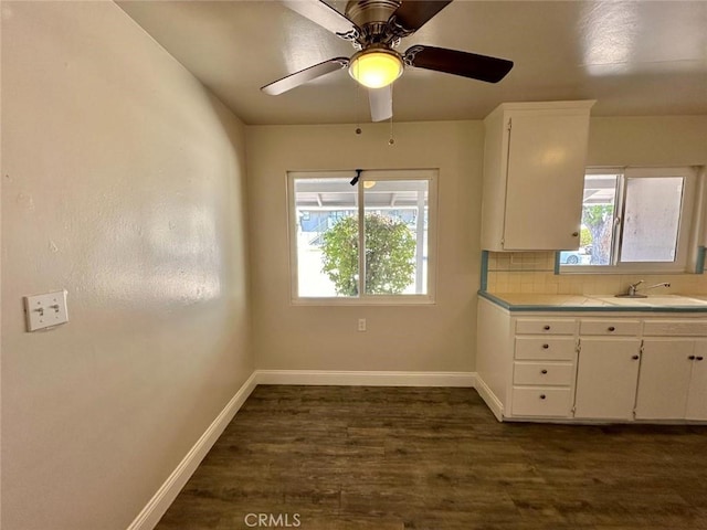 kitchen featuring ceiling fan, decorative backsplash, sink, and white cabinetry