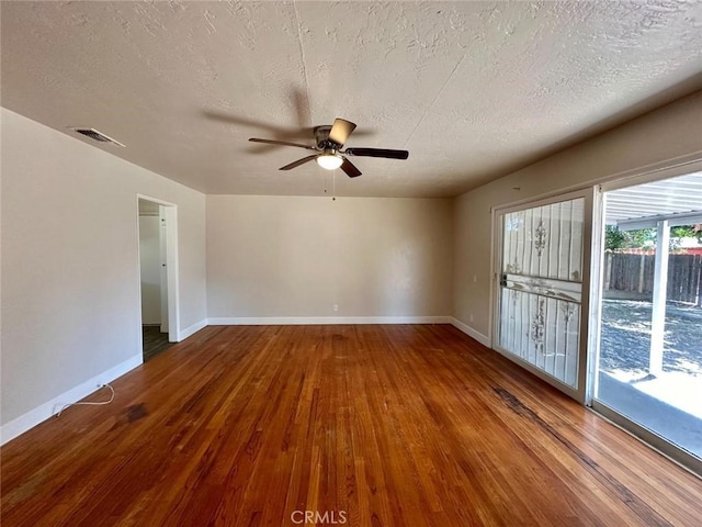 spare room featuring ceiling fan, wood-type flooring, and a textured ceiling