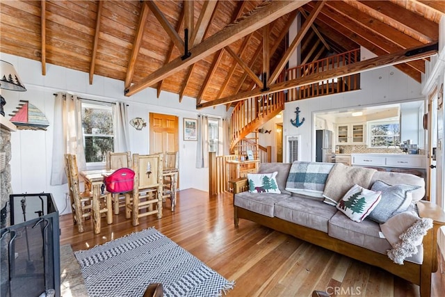 living room featuring wood ceiling, a fireplace, high vaulted ceiling, light hardwood / wood-style flooring, and beam ceiling