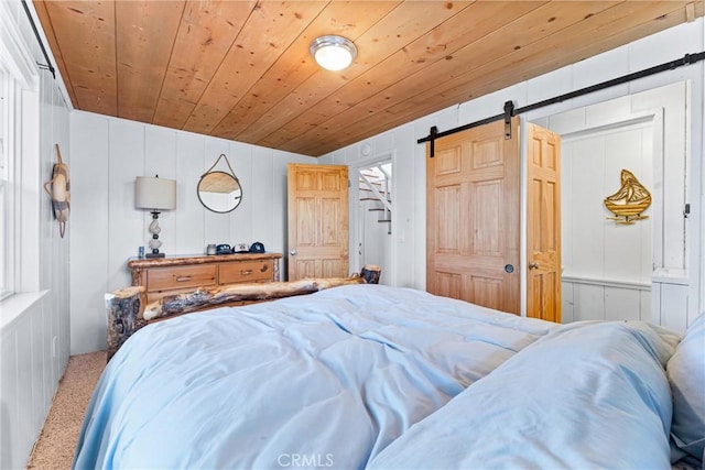347 Emerald Dr, Lake Arrowhead, CA 92352 - carpeted bedroom with a barn door, a decorative wall, and wooden ceiling