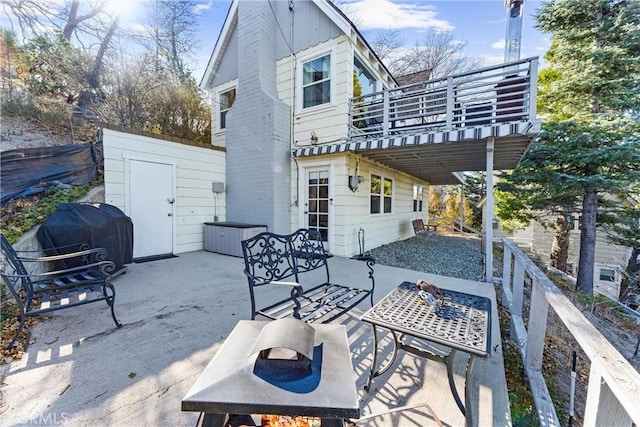 back of property featuring a deck, a shed, and a patio