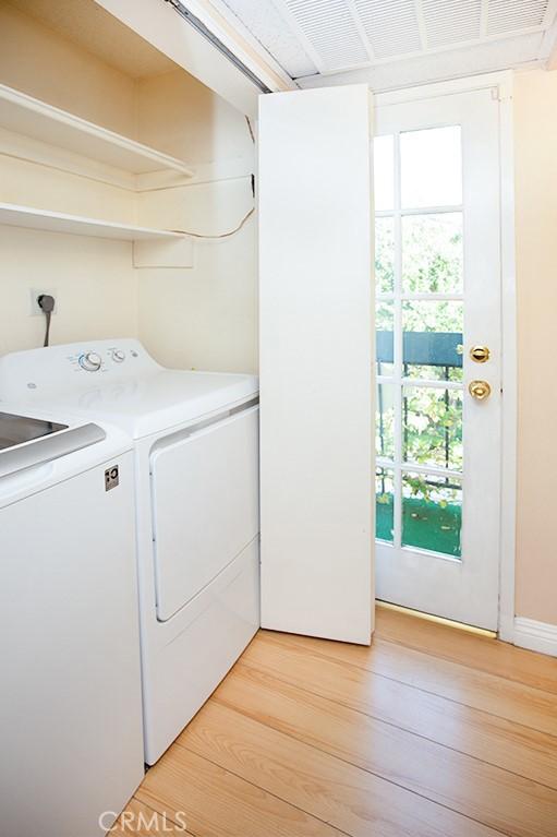 laundry room featuring independent washer and dryer and light wood-type flooring