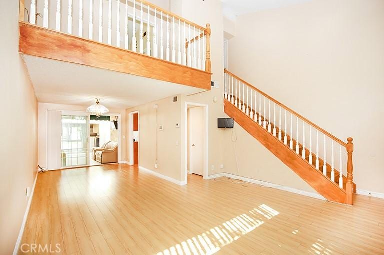 unfurnished living room featuring hardwood / wood-style floors and a high ceiling