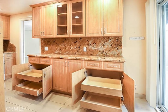 kitchen featuring light stone counters, light tile patterned floors, decorative backsplash, and light brown cabinets