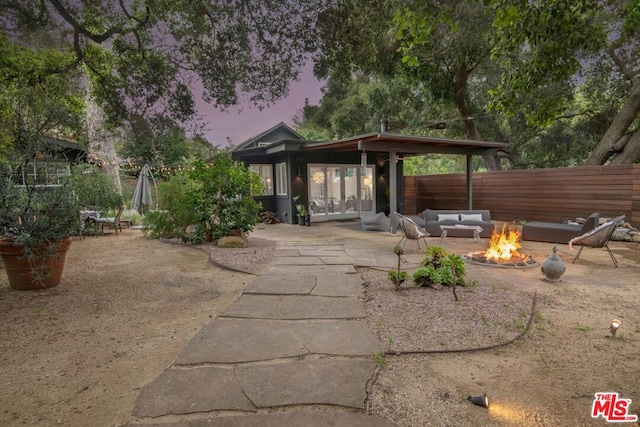 patio terrace at dusk featuring an outdoor living space with a fire pit