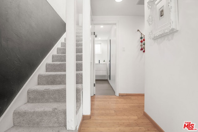 staircase with hardwood / wood-style floors