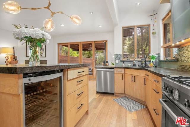 kitchen with beverage cooler, appliances with stainless steel finishes, light brown cabinets, decorative backsplash, and light hardwood / wood-style flooring