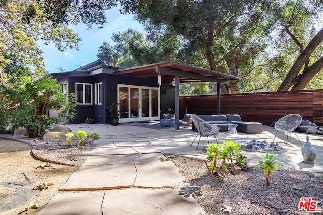 rear view of house featuring ceiling fan, an outdoor living space, french doors, and a patio