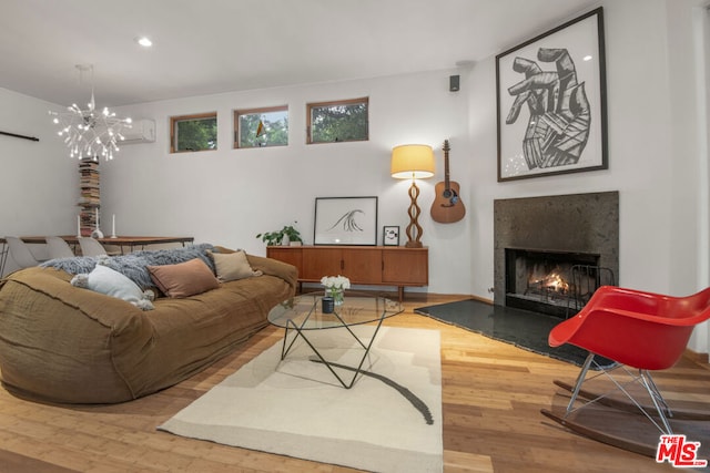 living room featuring light hardwood / wood-style floors, a high end fireplace, and a notable chandelier