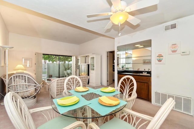 carpeted dining space featuring ceiling fan and sink