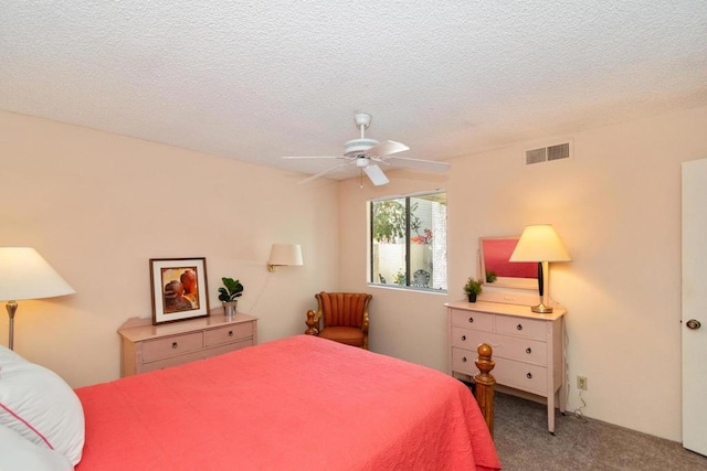 carpeted bedroom featuring ceiling fan and a textured ceiling