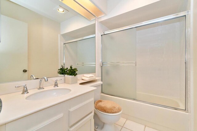 full bathroom featuring toilet, tile patterned flooring, enclosed tub / shower combo, and vanity