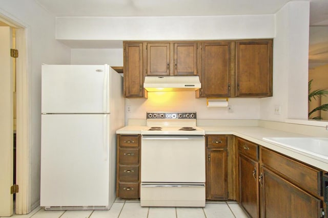 kitchen featuring light tile patterned floors, sink, and white appliances