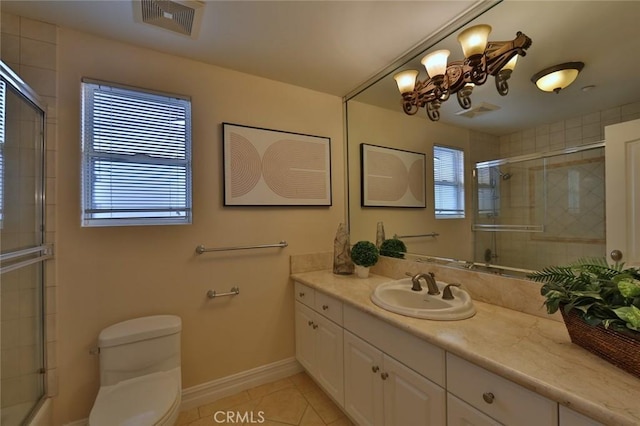 bathroom with an enclosed shower, vanity, tile patterned flooring, and toilet