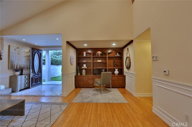 unfurnished office with lofted ceiling and light hardwood / wood-style flooring