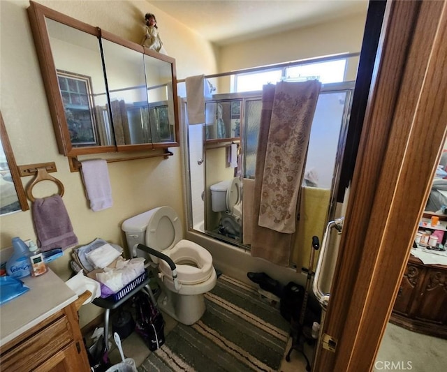 full bathroom featuring bath / shower combo with glass door, vanity, and toilet