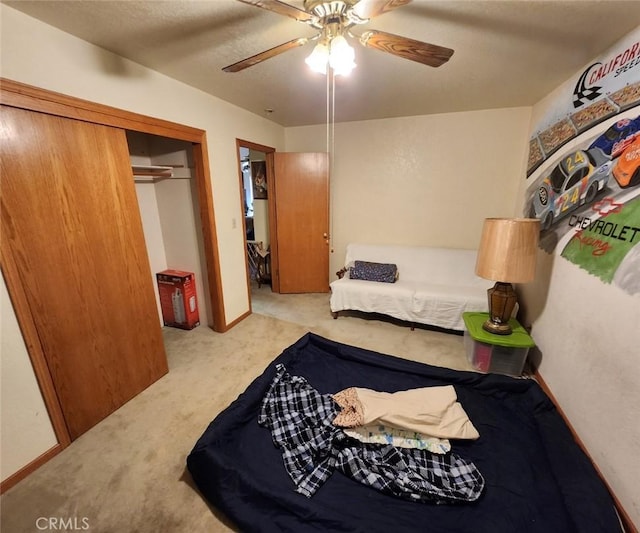 carpeted bedroom featuring ceiling fan and a closet