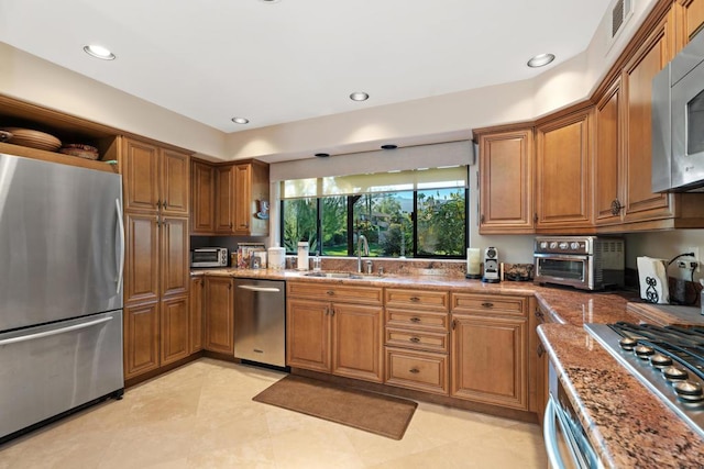 kitchen with sink, light stone counters, and stainless steel appliances