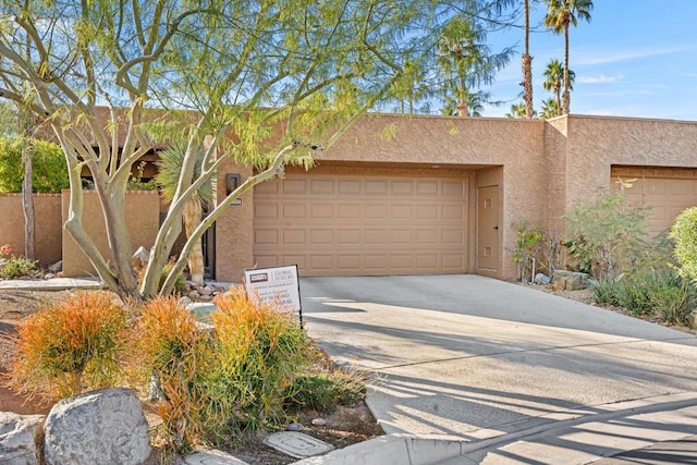 pueblo revival-style home with a garage