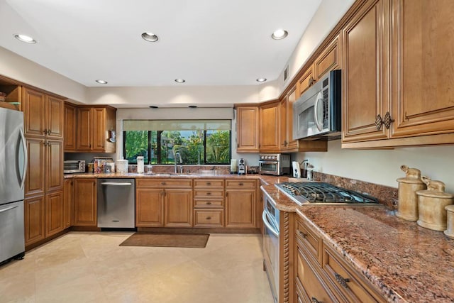 kitchen with sink, appliances with stainless steel finishes, and stone counters