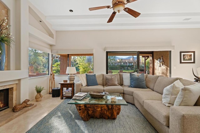 living room featuring light tile patterned floors, ceiling fan, plenty of natural light, and a tiled fireplace