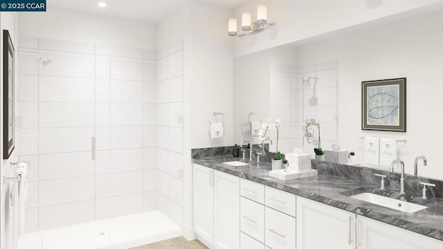 bathroom featuring a shower with shower door and vanity