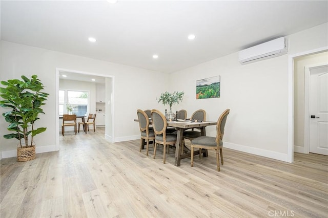 dining room featuring a wall mounted AC and light wood-type flooring