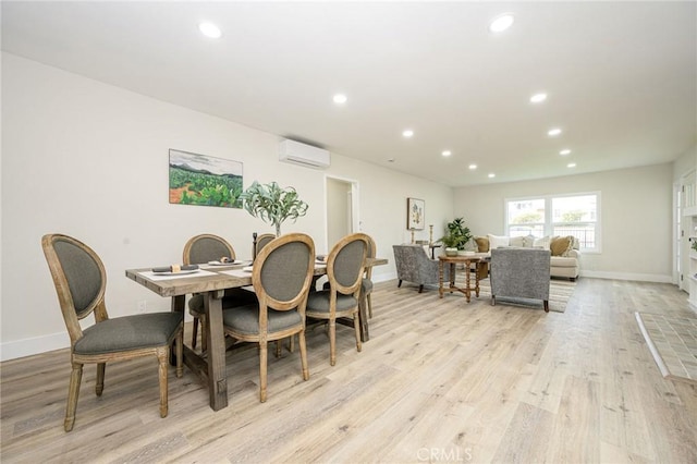 dining room with light wood-type flooring and a wall mounted air conditioner