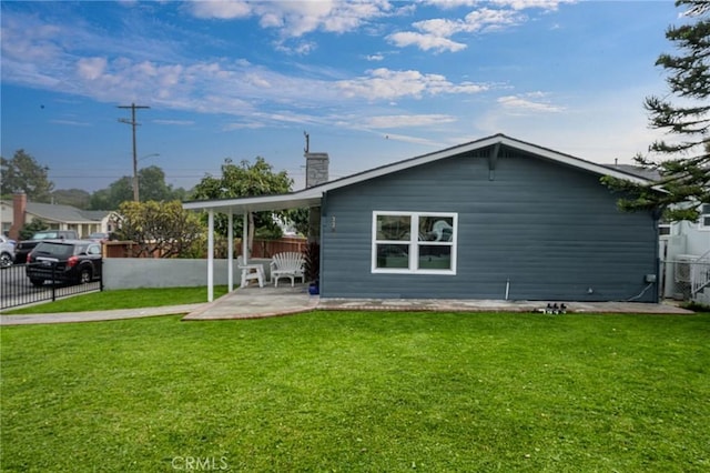 back of house with a lawn and a patio area